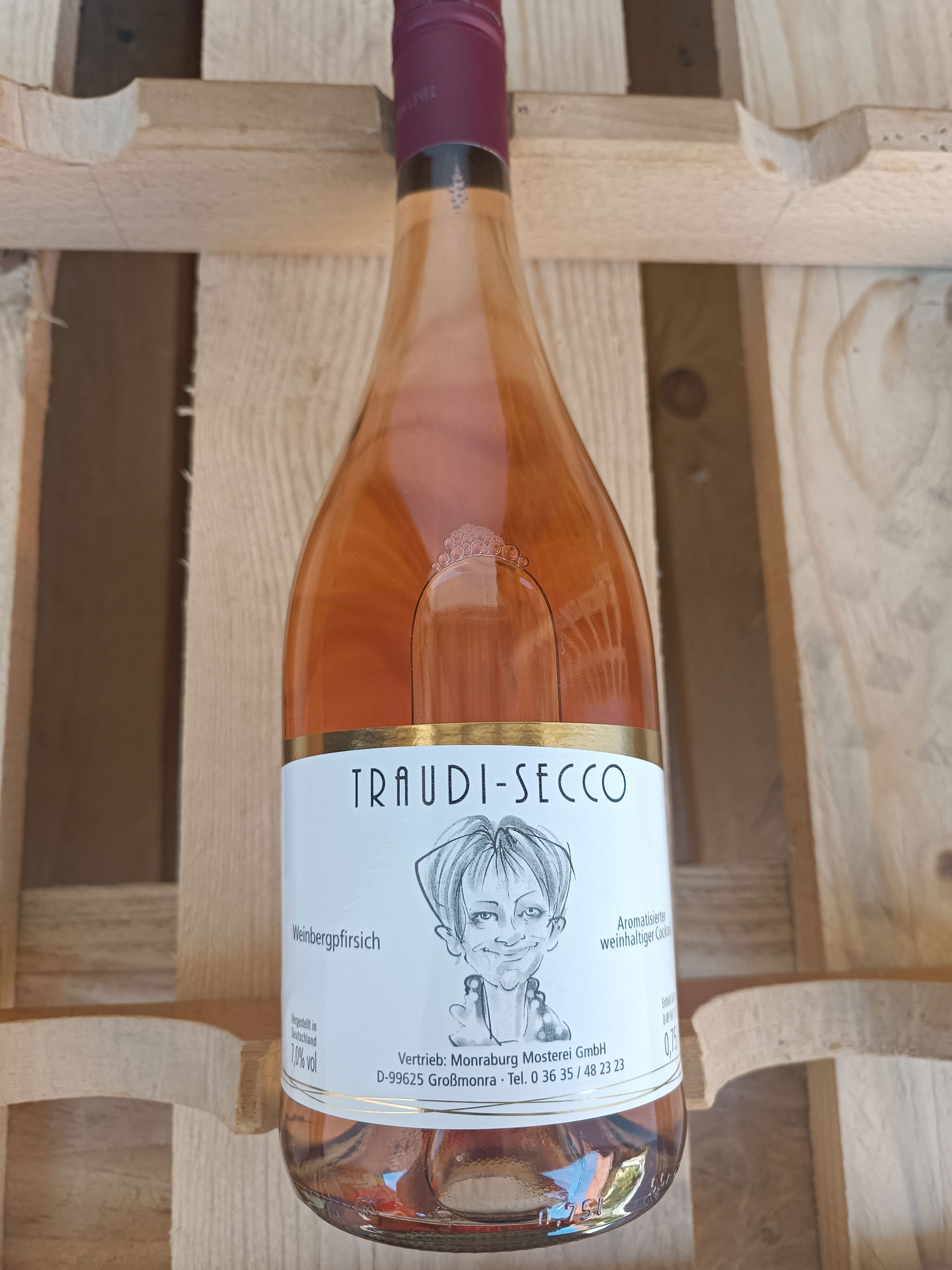Eine Flasche roséfarbenen Traudi-Secco auf einem hölzernen Hintergrund.